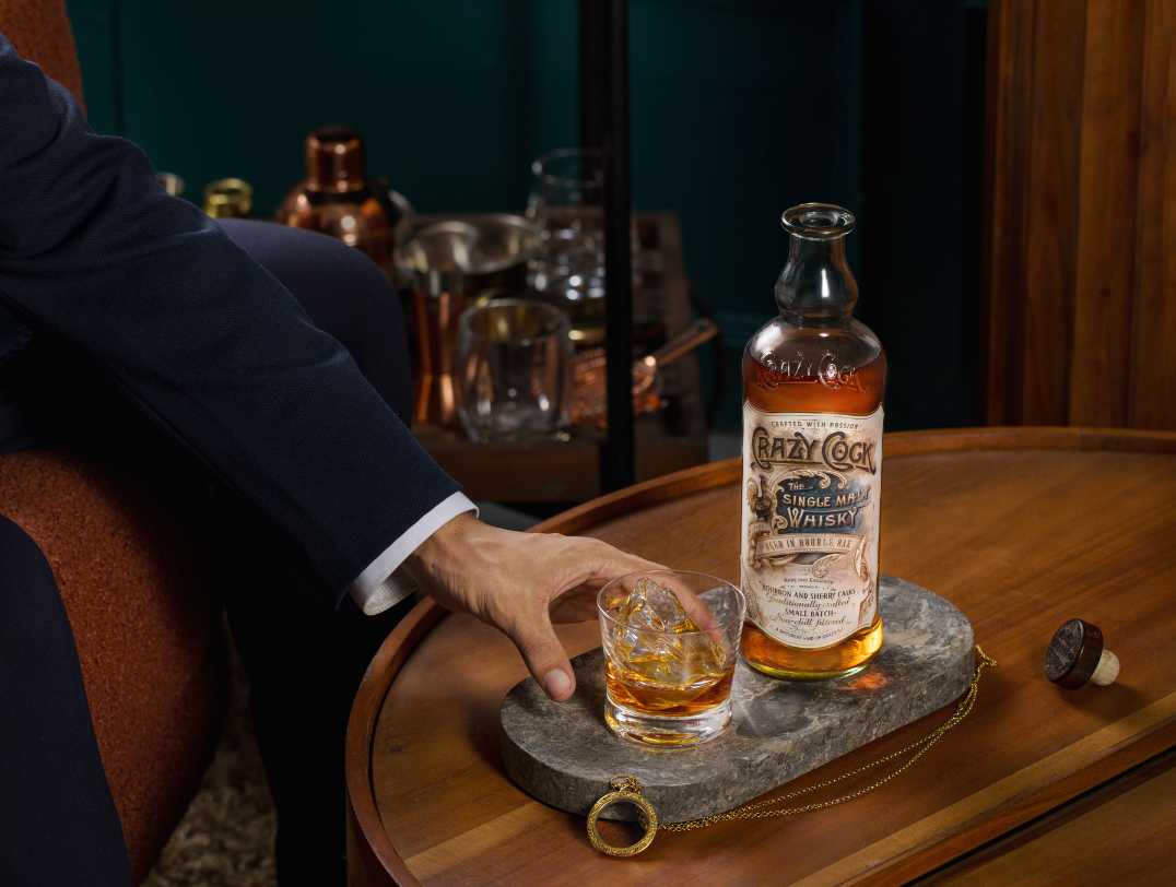 Single malt whisky served in a glass with a bottle in the background